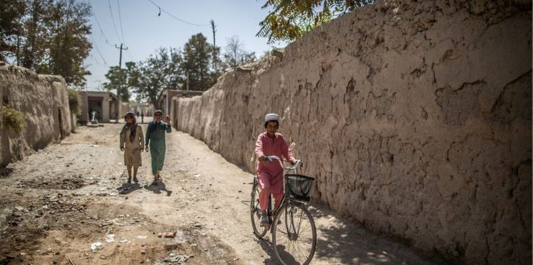 Ein afghanischer Junge fährt in Isa Khel außerhalb von Kundus Fahrrad.