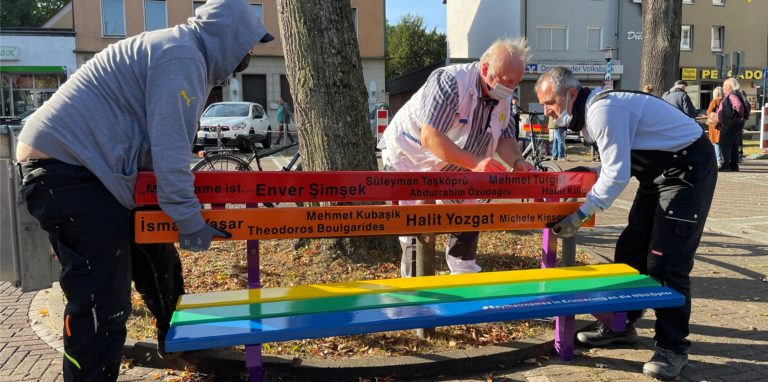 Die Bänke auf dem Wilhelmplatz sind zurück. Sie erstrahlen jetzt in Regenbogenfarben.