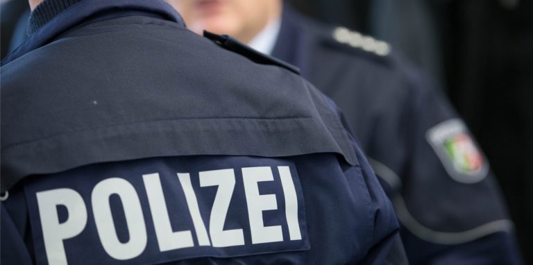 Eine blaue Polizeiuniform ist zu sehen. Auf der Jacke steht die Aufschrift Polizei. (Symbolbild)
