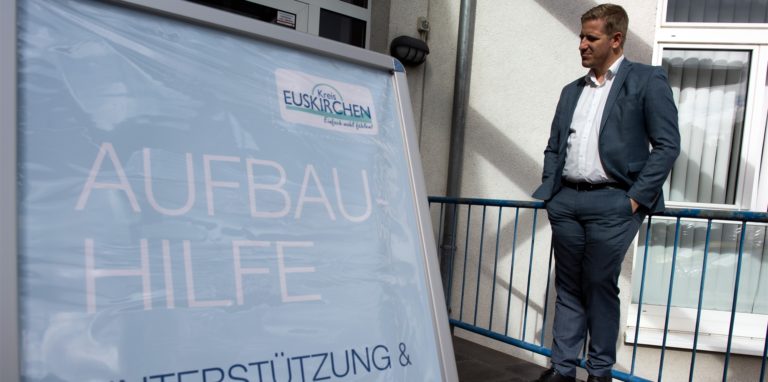 Markus Ramers (SPD), Landrat des Kreises Euskirchen, steht vor einer Beratungsstelle für Aufbauhilfe. Zwölf Wochen nach der Flutkatastrophe ist der Wiederaufbaufonds gefüllt.