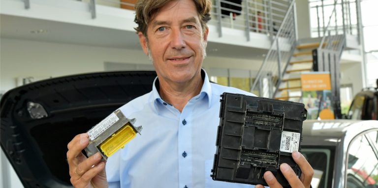 Christoph Haumann vom Autohaus Trompeter präsentiert ein Elektronikbauteil, das derzeit bei vielen Autos aufgrund des Halbleitermangels zu Lieferproblemen führt.
