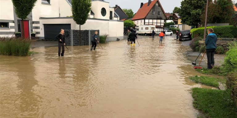 Das Wetter war schlecht, die Stimmung erstaunlich gut, als die Anwohner der Billmericher Dorfstraße hier auf die Straße gingen, um die Kanaleinläufe von der stetigen Neuverstopfung zu befreien. Der positive Geist in der Nachbarschaft ließ sich auch von den Sachschäden dieses Tages nicht vetreiben.
