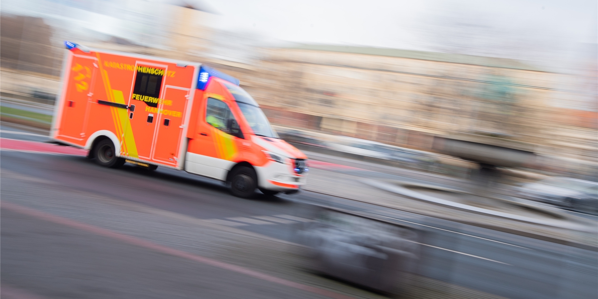 Ein Rettungswagen der Feuerwehr fährt mit Blaulicht durch die Innenstadt.