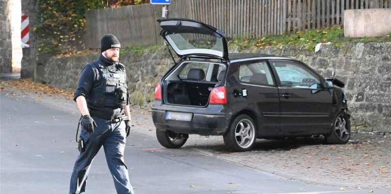 Ein Polizist geht an einem VW Polo vor einer Kindertagesstätte im Ortsteil Gertenbach vorbei. Dort soll ein Autofahrer absichtlich in eine Gruppe Kinder gefahren sein.