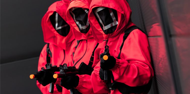 Mitarbeiter eines Kostümhändlers posieren in Kostümen aus der Serie „Squid Game“ des Streaming-Anbieters Netflix. Szenen aus der Serie sind offenbar beliebtes Schulhof-Spiel geworden.