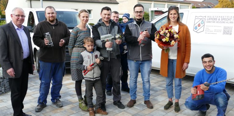 Das erfolgreiche erste Jahr in Schwerte feierten (v.l.): Mitarbeiter Bastian Fifielski, Katharina und Konstantin Specht mit Sohn Anton, Mitarbeiter Artur Handurdye (hinten), Jim Liffers und seine Verlobte Alina Krause sowie Auszubildender Mohammed Karout, sowie Volker Stein (l., Geschäftsstellenleiter Unna der Kreishandwerkerschaft Hellweg-Lippe).