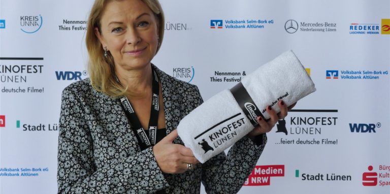 Dr. Anke Höwing, Mitglied des Ehrenrats des Kinofests, mit dem Badehandtuch des Festrivals, das sie als „Darstellerin“ des Films „Fabian“ bekommen hat.