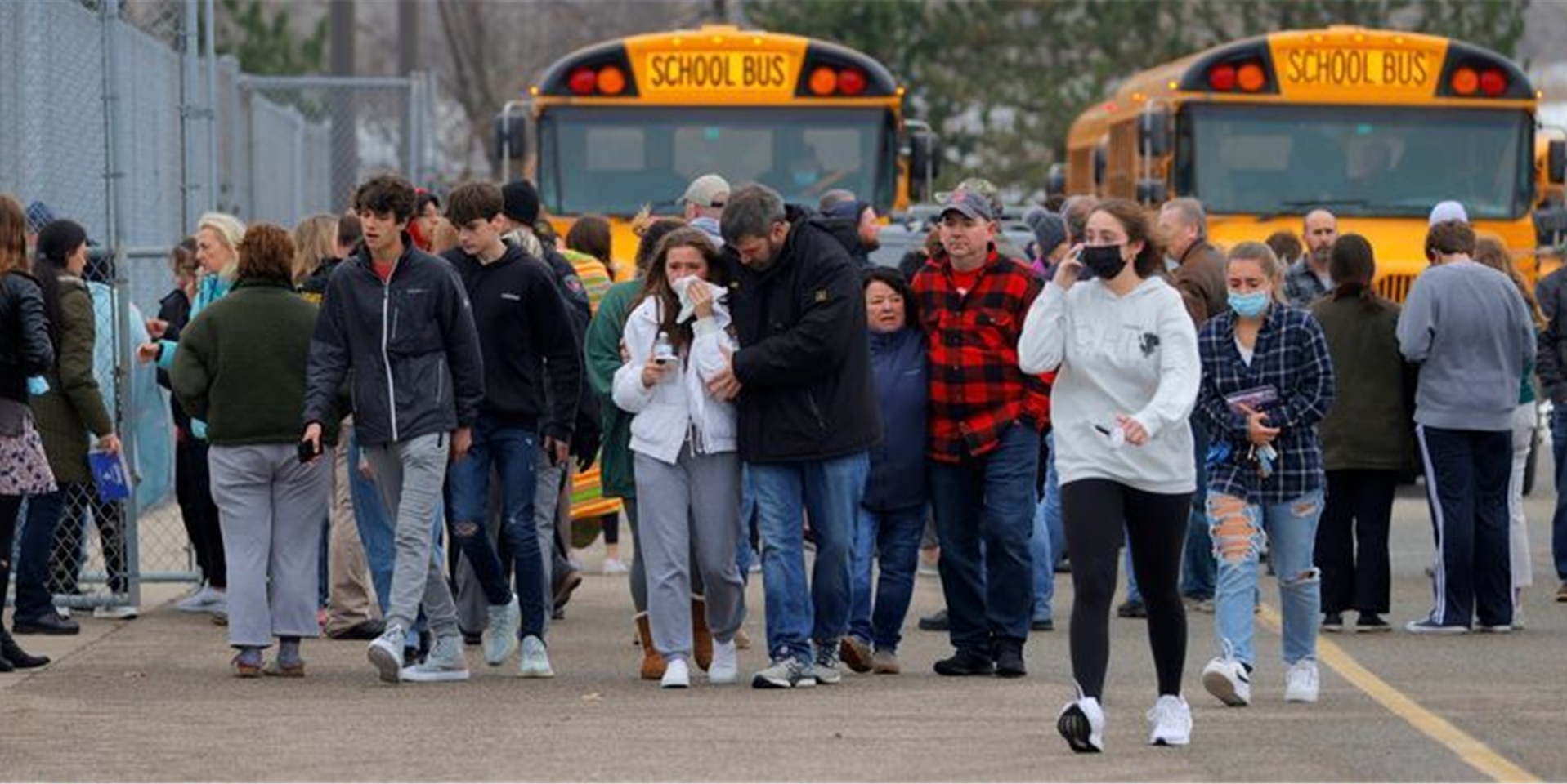 Eltern verlassen mit ihren Kindern einen Parkplatz, wo sich viele Schüler nach einer Schießerei an der Oxford High School im US-Bundesstaat Michigan versammelt haben.