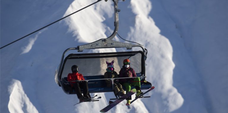 Skifahrer tragen FFP2-Schutzmasken in einem Sessellift im Skigebiet Silvretta Arena in Samnaun. Das Schweizer Samnaun betreibt mit Ischgl in Tirol (Österreich) ein gemeinsames Skigebiet.