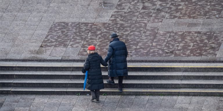 Ein älteres Paar geht gemeinsam über einen leeren Platz. Der Coronavirus-Expertenrat der Bundesregierung hat Kontaktbeschränkungen für die kommenden Tage empfohlen.