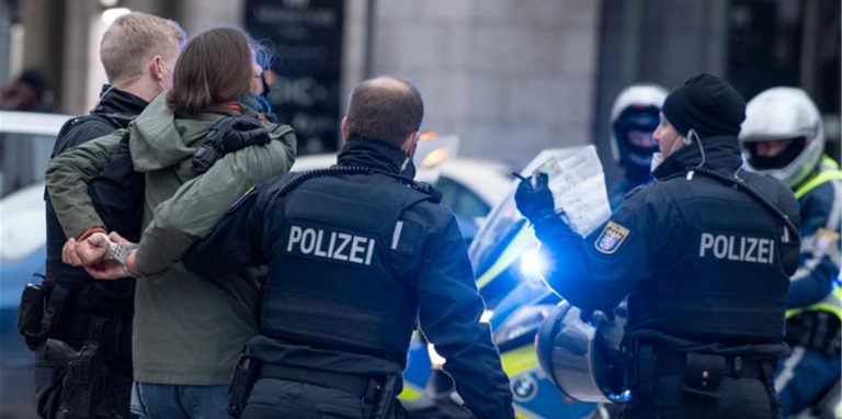 Polizisten in Frankfurt am Main nehmen eine Teilnehmerin einer Corona-Demonstration fest.