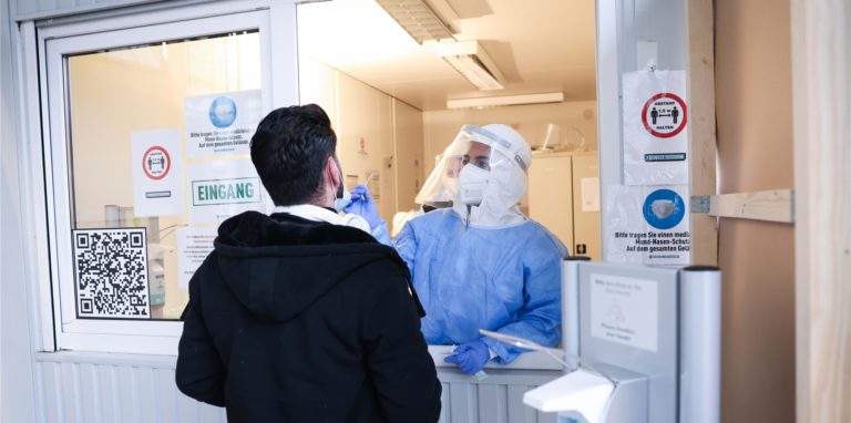 Eine Mitarbeiterin macht einen Corona-Schnelltest bei einem Mann an einer Teststation. (Symbolbild)