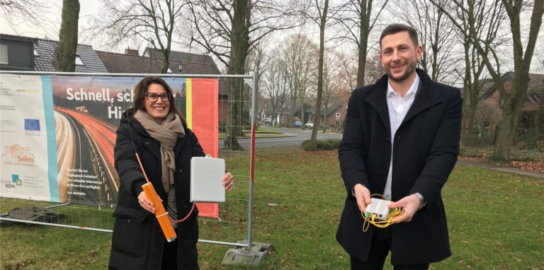 Sandra Sonnack und Markus Droste von Westenergie halten ein Optical Network Terminal (ONT) und einen Kasten der Abschlusspunktline (APL), die für schnelles Internet notwendig sind.