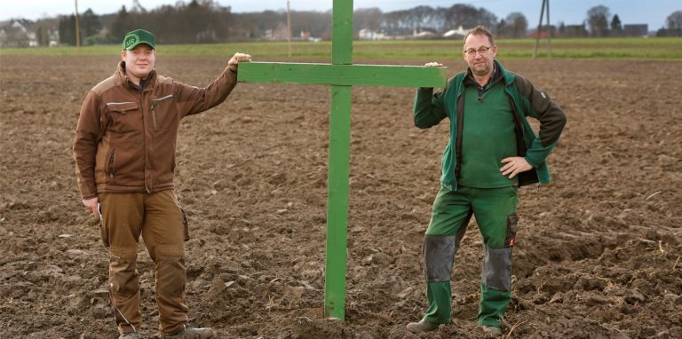 Hans-Heinrich Wortmann und sein Sohn Henrik stehen auf einem ihrer Äcker neben einem Grünen Kreuz. Die Landwirte aus Methler machten bereits mehrfach Aktionen auf die schwierige Lage der Bauern aufmerksam.