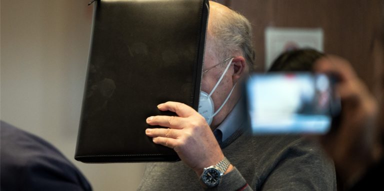 Der angeklagte katholische Priester hält sich im Gerichtssaal eine Mappe vor das Gesicht. Er wird wegen sexuellen Missbrauchs angeklagt. Der 70-Jährige soll in den 1990er Jahren in 31 Fällen seine damals zwischen 7 und 13 Jahre alten Nichten missbraucht haben.