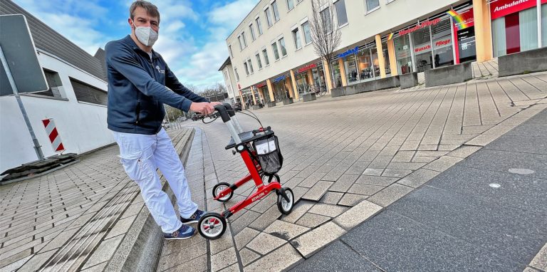 Daniel Vatheuer vom Sanitätshaus Tingelhoff im Severinshaus, demonstriert die Probleme, die viele Kunden haben, wenn sie die Nordenmauer überqueren. Die Stadt kündigte an, die Straße sanieren.