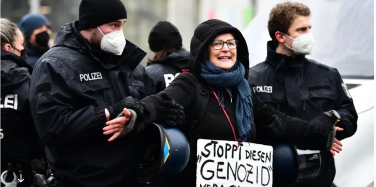 Eine Demonstrantin, die den Holocaust relativiert, wird abgeführt.