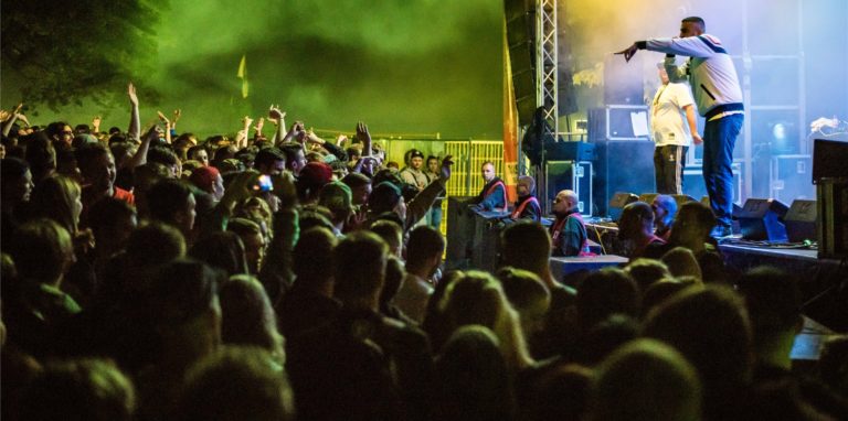 Rapper steht bei einem Festival (vor der Corona-Pandemie) auf der Bühne.