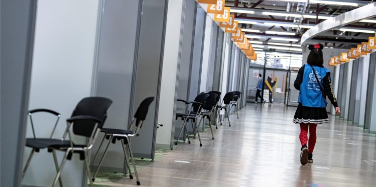 Eine Mitarbeiterin läuft durch das fast leere Impfzentrum Tegel.