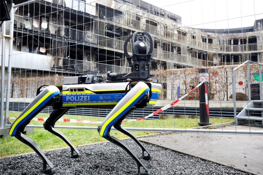 Ein Polizei-Roboter ist am ausgebrannten Wohnkomplex im Einsatz. Mit dem 35 Kilogramm schweren Laufroboter soll das einsturzgefährdete Gebäude nach dem Ende der Löscharbeiten erkundet werden. Der bei einem Brand am Montag zerstörte Wohnkomplex in Essen war ein Neubau von 2015, der gemäß den Bauvorschriften mit Brandschutztüren gegen eine schnelle Verbreitung eines Feuers ausgestattet war.