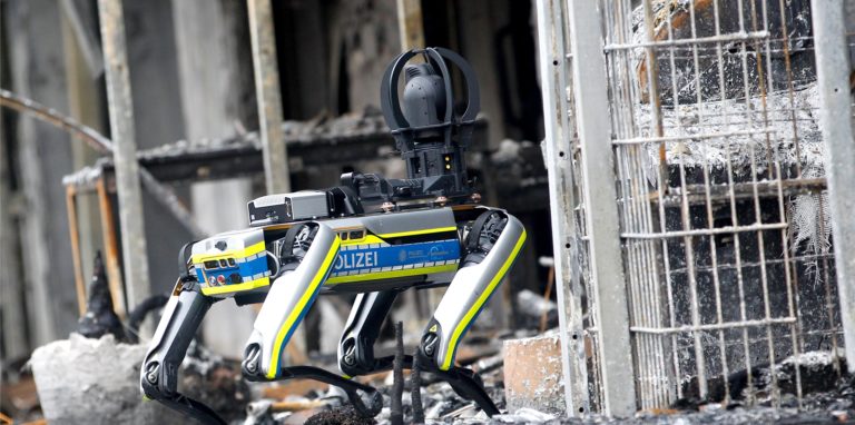 Ein Polizei-Roboter ist am ausgebrannten Wohnkomplex im Einsatz. Mit dem 35 Kilogramm schweren Laufroboter soll das einsturzgefährdete Gebäude nach dem Ende der Löscharbeiten erkundet werden.