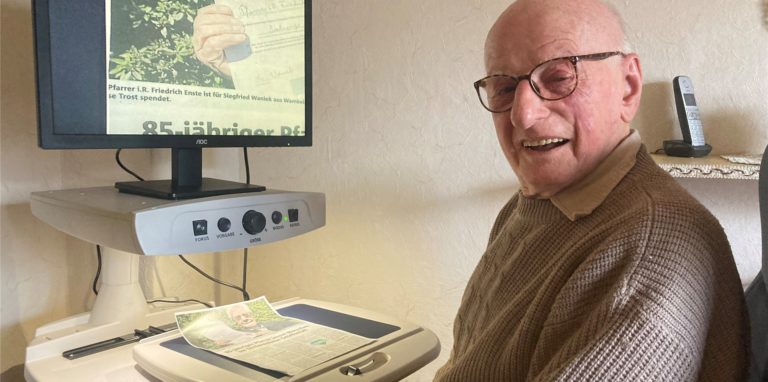 Siegfried Waniek verfolgt auch mit 94 Jahren das Weltgeschehen noch mit großer Aufmerksamkeit – auch mithilfe eines Lesegeräts für die Zeitungslektüre.