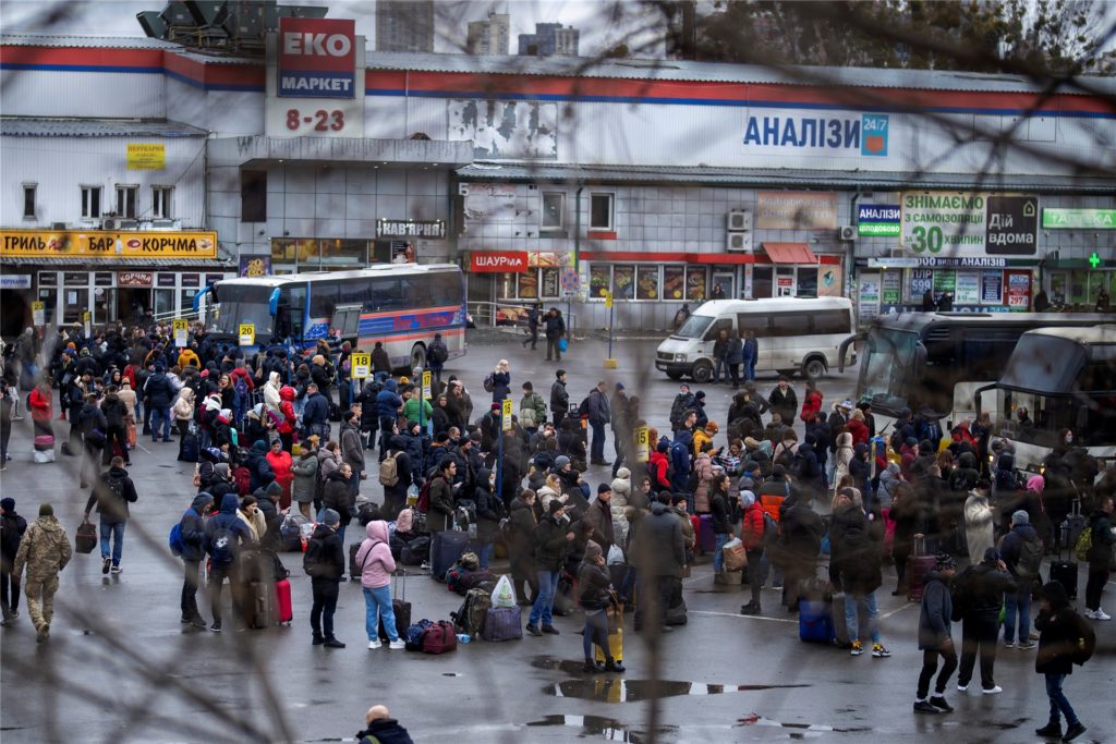 Menschen versuchen in Busse zu steigen, um Kiew zu verlassen. Menschen versuchen in Busse zu steigen, um Kiew zu verlassen.