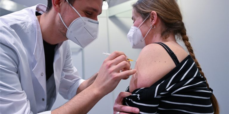 Christopher Riffel (l) vom Klinikum Stuttgart impft eine Klinikmitarbeiterin in einer Impftstaion in Stuttgart gegen das Coronavirus.