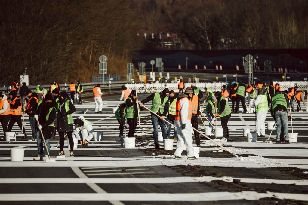 Zahlreiche Künstler stehen auf der gesperrten Rahmedetalbrücke der Autobahn 45 und malen eine Friedensbotschaft auf den Asphalt. Zahlreiche Künstler stehen auf der gesperrten Rahmedetalbrücke der Autobahn 45 und malen eine Friedensbotschaft auf den Asphalt.