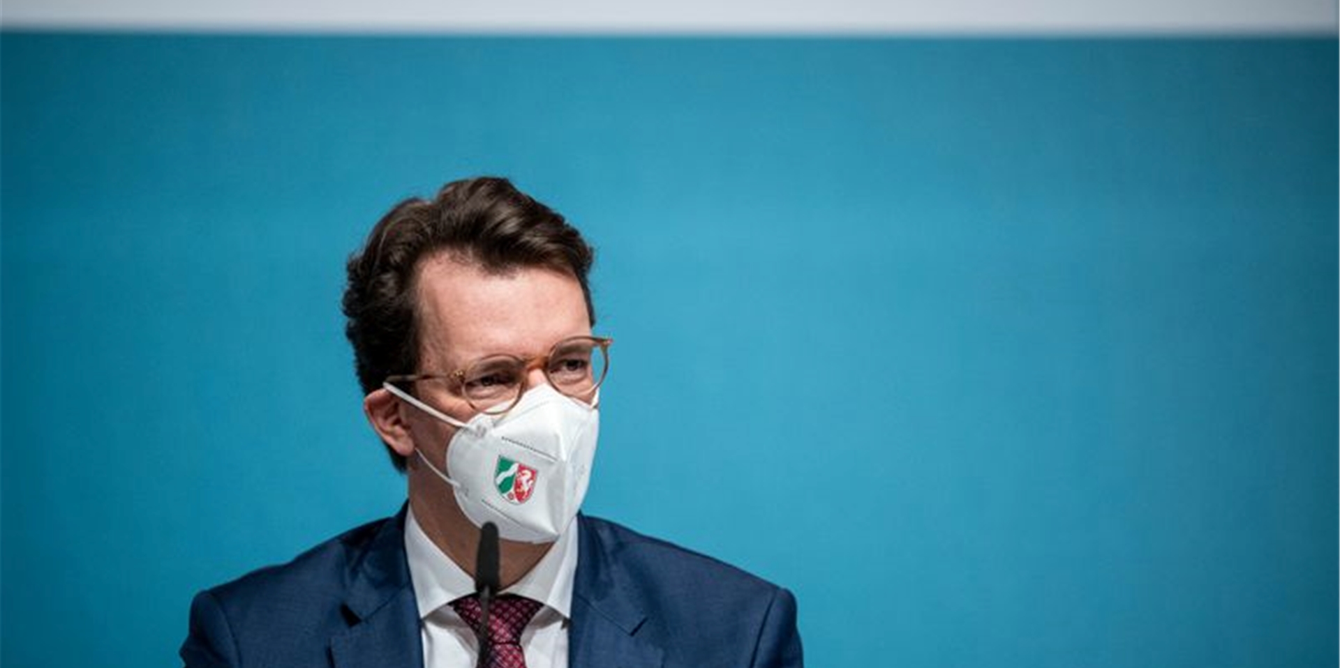 Hendrik Wüst (CDU), Ministerpräsident von Nordrhein-Westfalen, sitzt auf dem Podium.