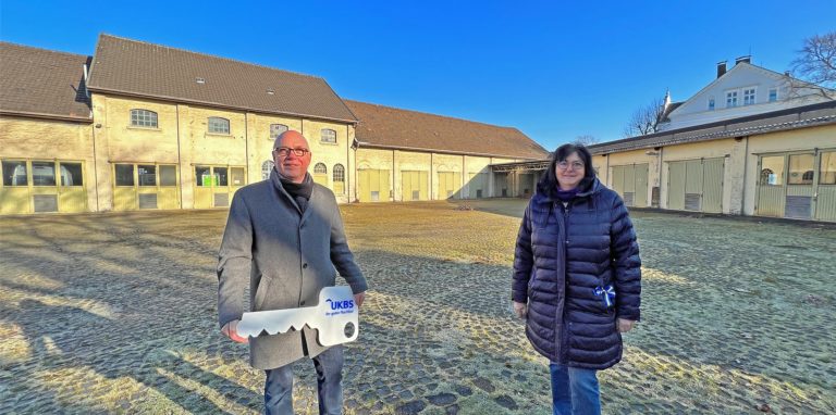 Matthias Fischer, Geschäftsführer der UKBS, und Bürgermeisterin Elke Kappen auf dem gepflasterten Hof der Polizeikaserne an der Dortmunder Allee. Im Hintergrund liegt die zur Borsigstraße liegende Werkstatt, die abgerissen werden soll.