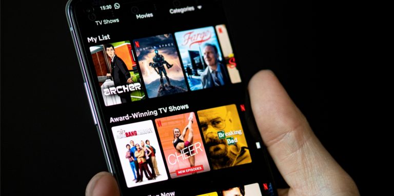 Auf dem Bildschirm eines Smartphones sieht man in der App von Netflix das Filmangebot des Streaminganbieters.
