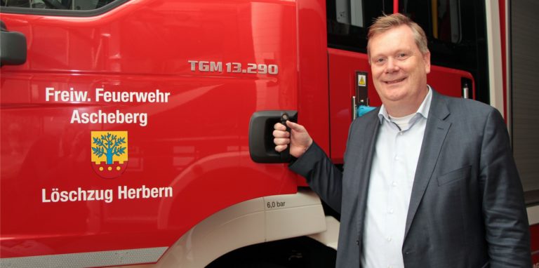 Aschebergs Bürgermeister Thomas Stohldreier vor einem Feuerwehrauto
