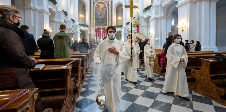 Ministranten prozessieren beim Weihnachtsgottesdienst durch eine Kathedrale.