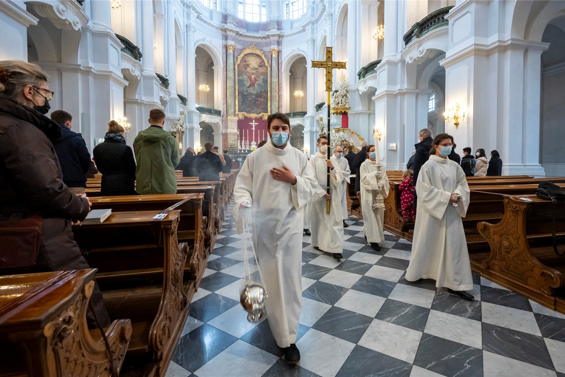 Ministranten prozessieren beim Weihnachtsgottesdienst durch eine Kathedrale.