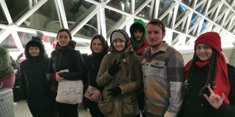 Ukrainer stehen neben ihren Helfern