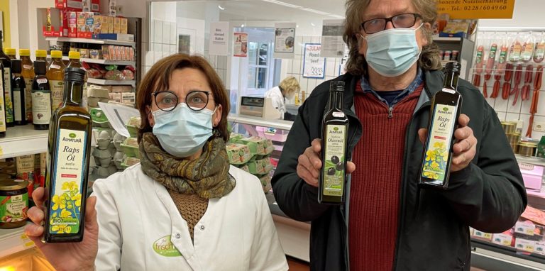 Eine Frau und ein Mann mit Ölflaschen in der Hand
