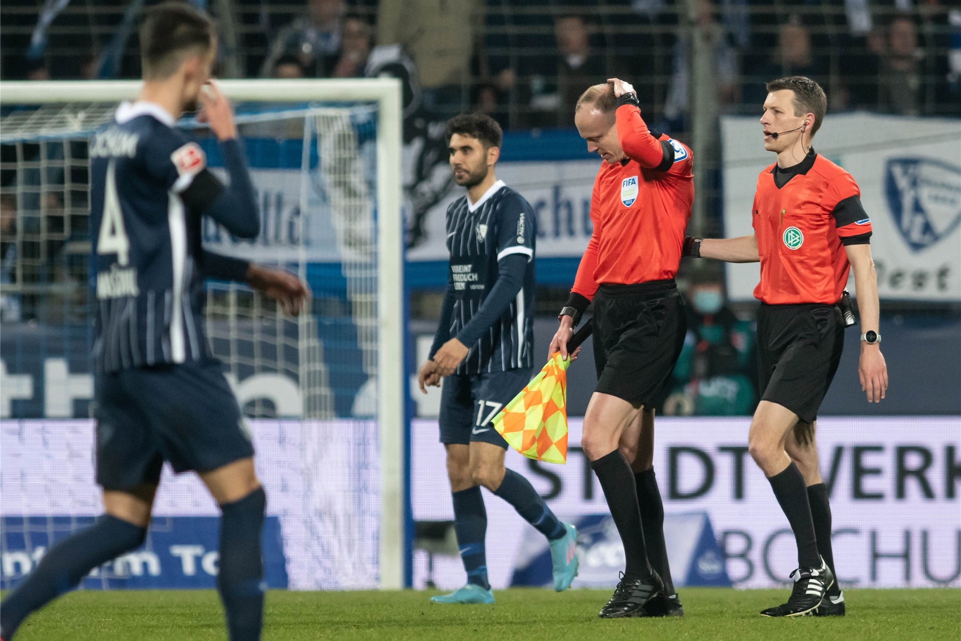 Das Schiedsrichtergespann um Benjamin Cortuns (r) verlässt während des Spiels das Spielfeld, nachdem Schiedsrichterassistent Christian Gittelmann (2.v.r.) einen Becher an den Kopf bekommen hatte.