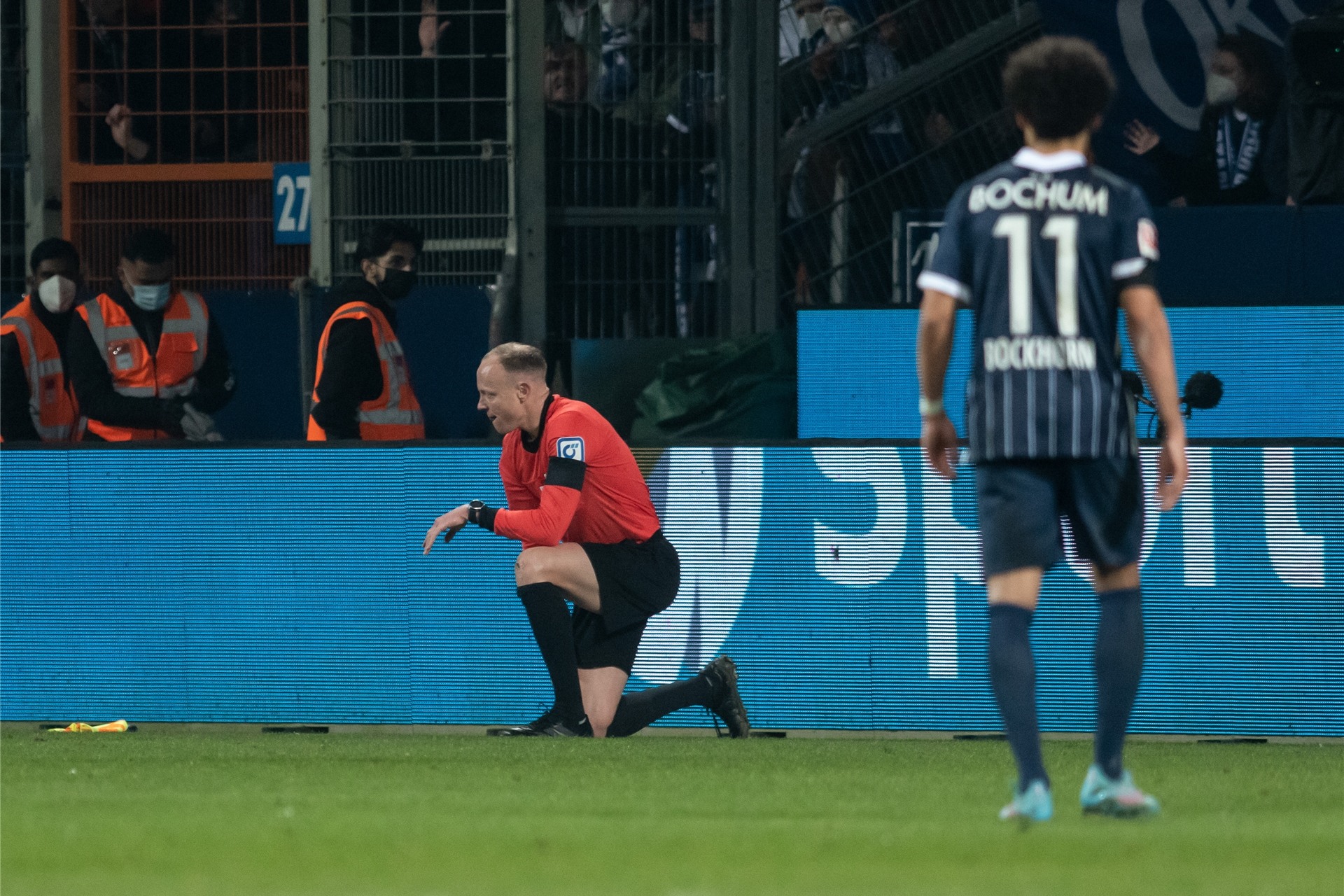 Der Schiedsrichterassistent Christian Gittelman, der einen Becher an den Kopf bekommen hatte, kniet auf dem Platz.