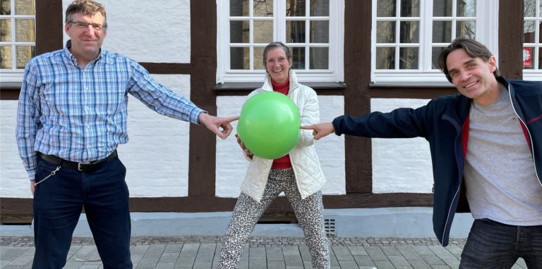 Andreas Drohmann, Uta Kurz und Dr. Roland Lach halten einen grünen Ball