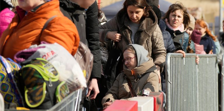 Aus der Ukraine geflüchtete Menschen stehen in einer Schlange am polnisch-ukrainischen Grenzübergang in Medyka und warten auf Transportmittel, um weiterzureisen.
