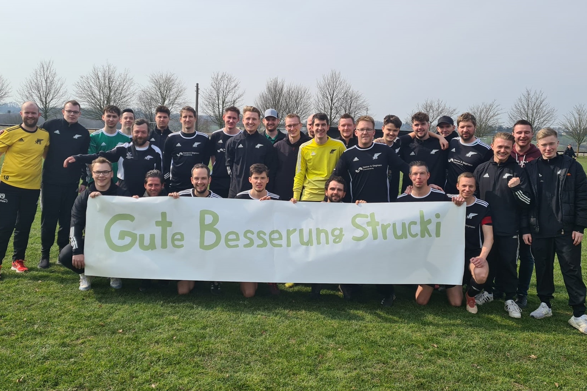 Die Spieler und Betreuer des SV Bausenhagen II hielten vor der Partie gegen den BSV Heeren II dieses Plakat hoch. Ihr Spieler Frederick Struck hatte sich zuvor lebensgefährlich verletzt