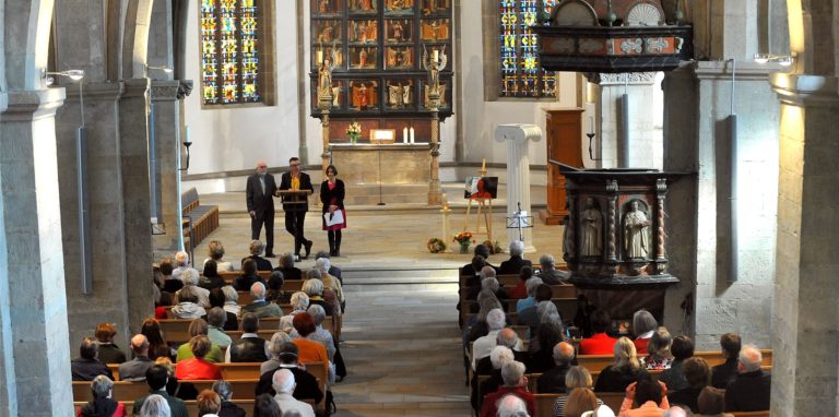 Mit rund 250 Besuchern gut gefüllt war die Viktorkirche bei der Trauerfeier für die am 30. Dezember gestorbene Gerlinde Heinrich. Dabei sprachen (hinten, v.l.) der Ehemann Prof. Carl-Joachim Heinrich sowie die Kinder Prof. Anselm Heinrich und Prof. Caroline Heinrich. Rechts im Altarraum steht die weiße antike Theatersäule, die die Gestorbene für ihre Inszenierung der Komödie „Lysistrata“ benutzt hatte.