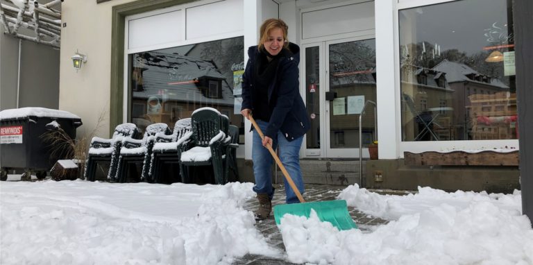 Oya Soyigitt räumt am frühen Samstagmorgen den Schnee vor dem Café Melange. Zuvor war bereits der Marktplatz durch die Stadtwerke Fröndenberg Wickede weitgehend von den Schneemassen befreit worden.