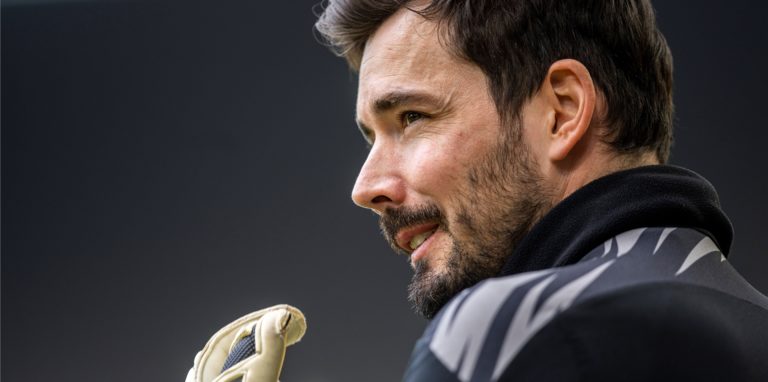 BVB-Keeper Roman Bürki schaut nach links und richtet seinen Torwarthandschuh.