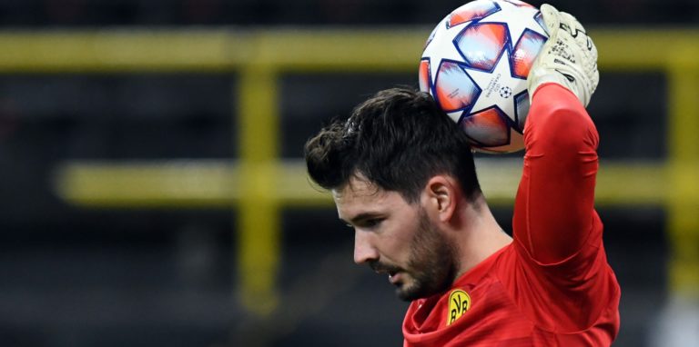 BVB-Keeper Roman Bürki hält einen Fußball und presst ihn sich mit der linken Hand an den Hinterkopf.
