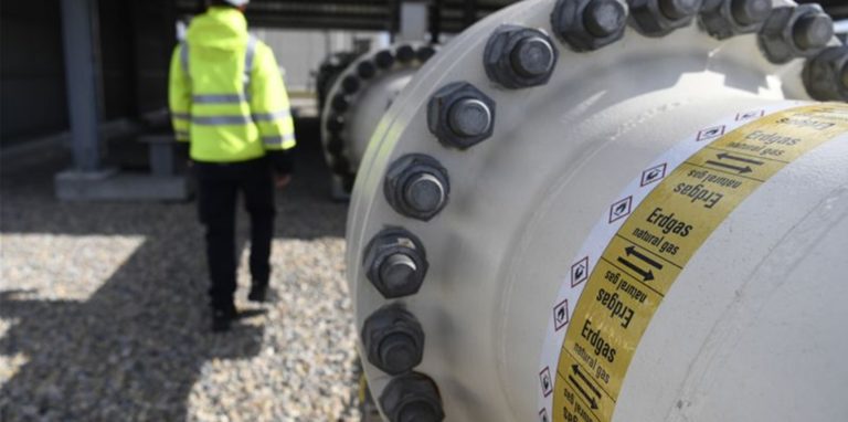 Ein Mitarbeiter geht an einem Teil einer Erdgasleitung am Gelände der Gas Connect Austria Verdichterstation.