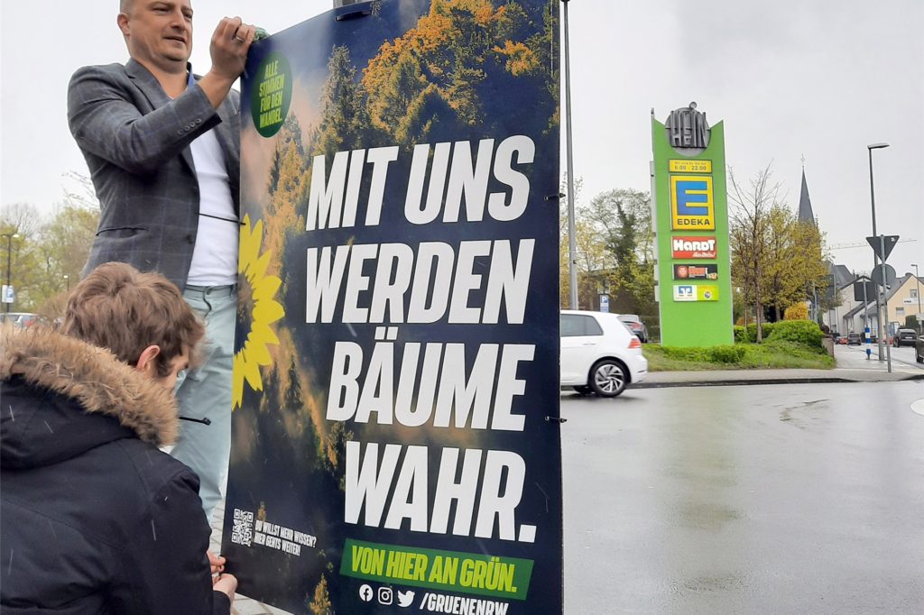 Zwei Parteimitglieder der Grünen hängen in NRW ein Plakat mit der Aufschrift Zwei Parteimitglieder der Grünen hängen in NRW ein Plakat mit der Aufschrift