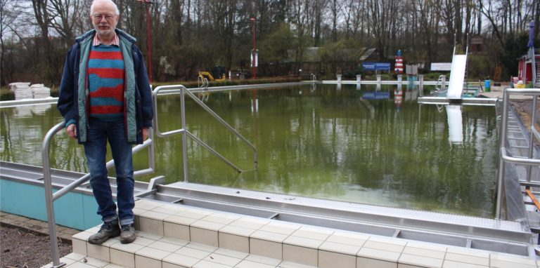 Thomas Wild am Schwimmbecken, in dem sich noch das Winter-Wasser befindet. Das kann erst abgepumpt werden, wenn die Umwälztechnik angeschlossen ist. Das hat sich verzögert.