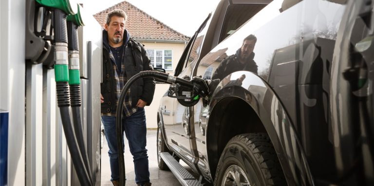 Ein Mann betankt sein Auto an einer Tankstelle.